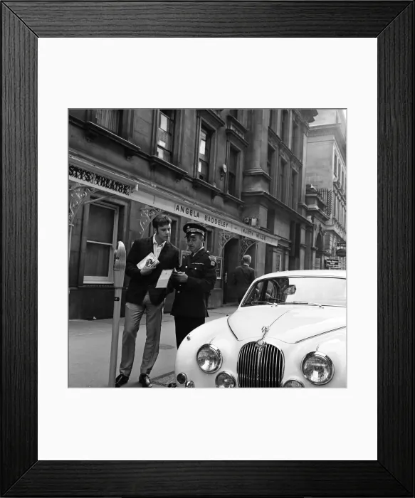 Framed Print : Pop star Marty Wilde, 22, is given a parking ticket after parking his cream Jaguar Framed Print : Pop star Marty Wilde, 22, is given a parking ticket after parking his cream Jaguar