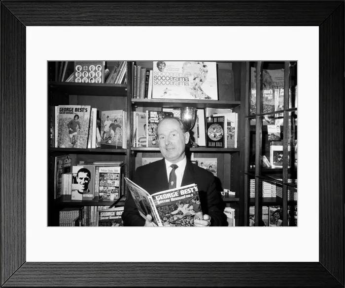 Framed Print : Football agent Ken Stanley reading a George Best annual. 18th February 1970