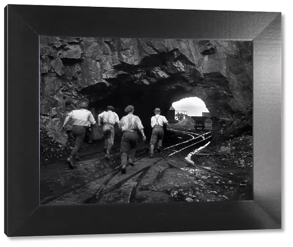 Men running through a tunnel, cut out by the quarrymen, to take cover during the blasting