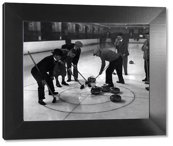 Brushing a stone in during a curling match between Belle Vue
