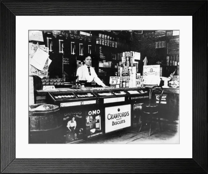 Framed Print : A woman behind the counter of a general store. Cambridge, Cambridgeshire. Circa 1920 Framed Print : A woman behind the counter of a general store. Cambridge, Cambridgeshire. Circa 1920
