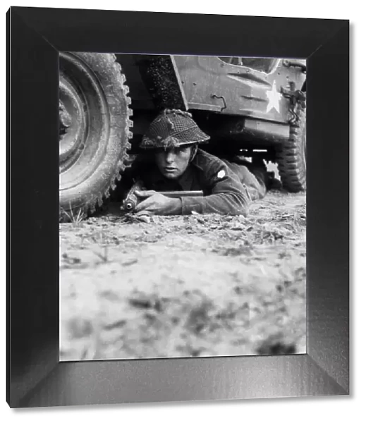 Rifleman Brett of Newport, Isle of Wight, takes cover beneath his vehicle when on look