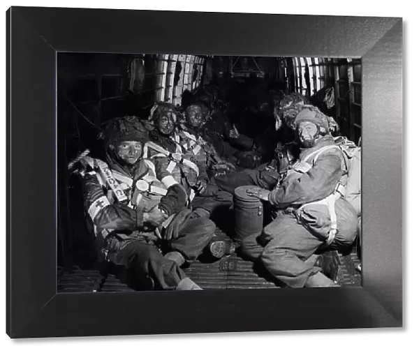Camouflaged with blackened faces, paratroopers take up their position in their aircraft