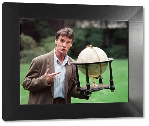 Writer and actor Michael Palin with a globe. 8th October 1992