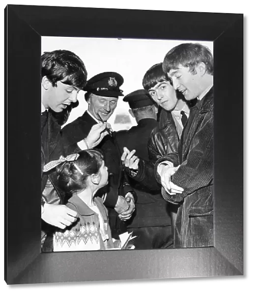 The Beatles chat with a young fan, and sign for her their autographs