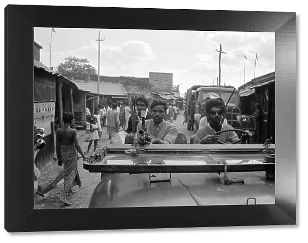 India - War Scenes - 1971 men driving through a street armed with guns