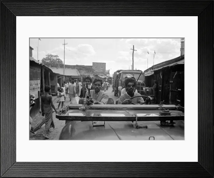 Framed Print : India - War Scenes - 1971 men driving through a street armed with guns Framed Print : India - War Scenes - 1971 men driving through a street armed with guns