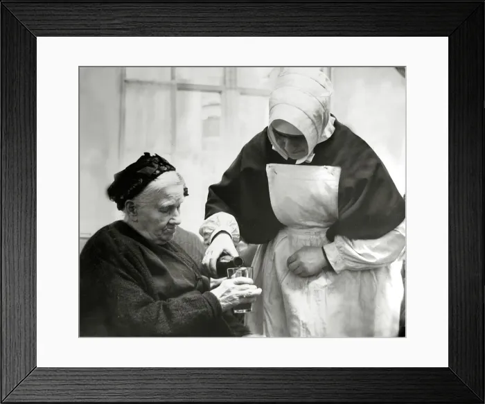 Framed Print : Old People - Poverty Nun helping out - pouring a drink