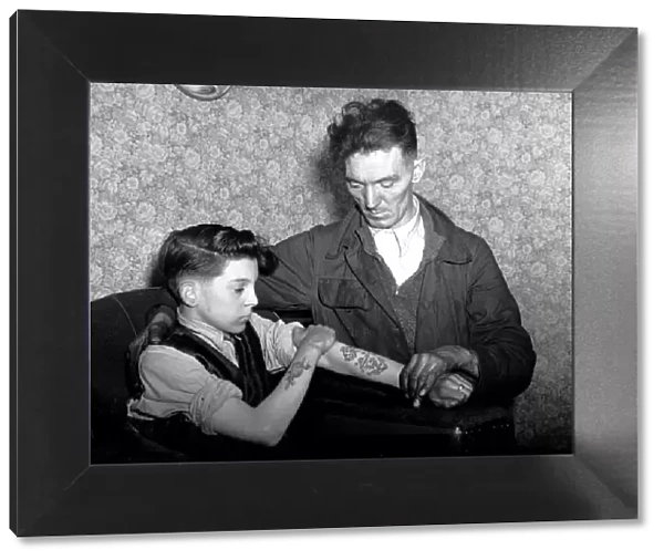 14-year-old Arthur Waterworth of Droylsden shows off his tattooed forearms to his father