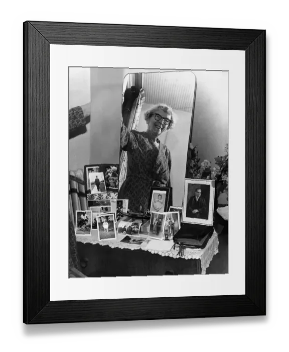Framed Print : Old woman smiling at bedroom mirror in her newly-built Home. 9th october 1963