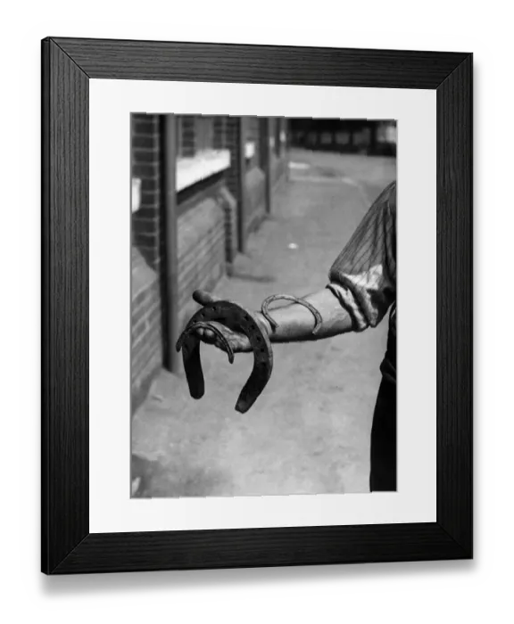 Framed Print : A man holding various horseshoes. 1st June 1922 Framed Print : A man holding various horseshoes. 1st June 1922