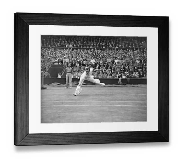 Framed Print : Fred Perry (GB) plays a back hand shot at the net, competing at the Wimbledon Tennis Mens