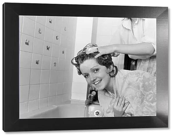The Nolan sisters at home in Ilford. Bernadette helps Linda to wash her hair
