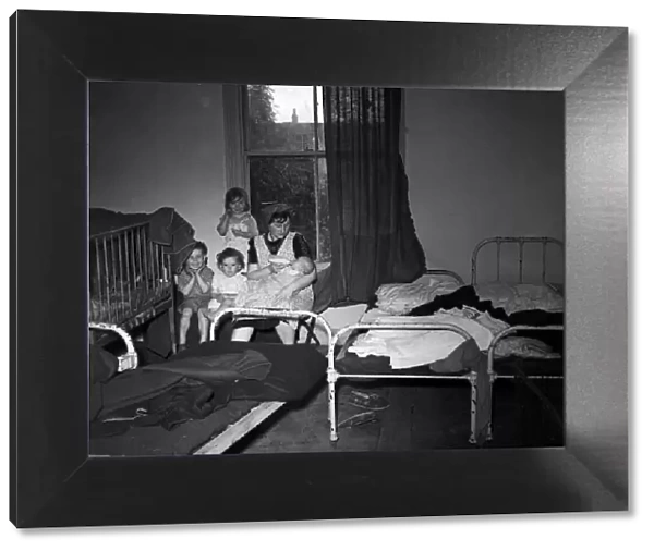 A mother of No. 198 Colman Street, Hull, with her children in one bedroom. 9th July 1953