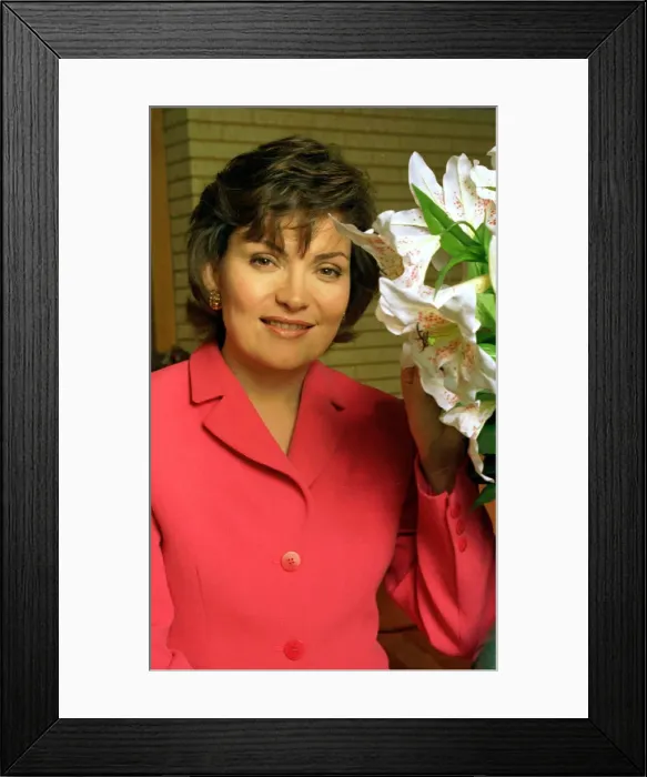 Framed Print : Lorraine Kelly TV presenter wearing a pink suit poses with some flowers Framed Print : Lorraine Kelly TV presenter wearing a pink suit poses with some flowers