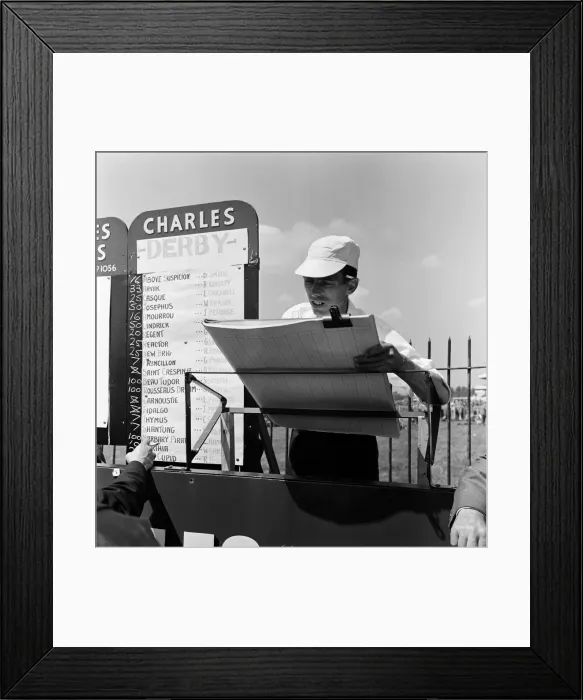 Framed Print : A scene at Derby Day at Epsom. A bookies clerk complete with white hat busily Framed Print : A scene at Derby Day at Epsom. A bookies clerk complete with white hat busily