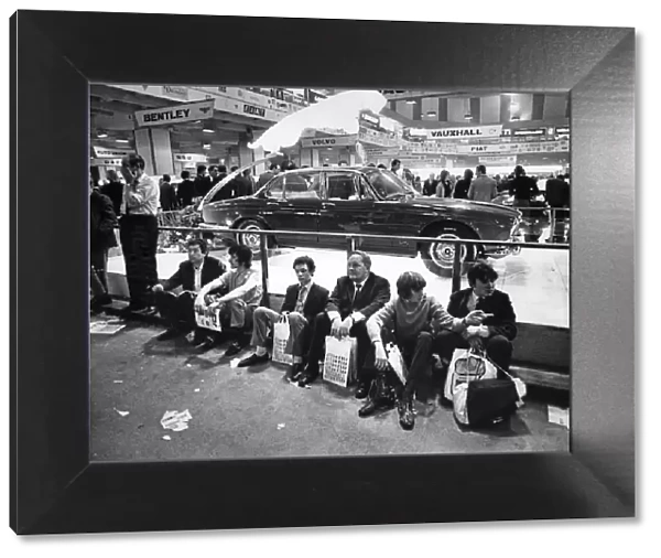 The Earls Court Motor Show. London Visitors sit on the floor in front of the Jaguar