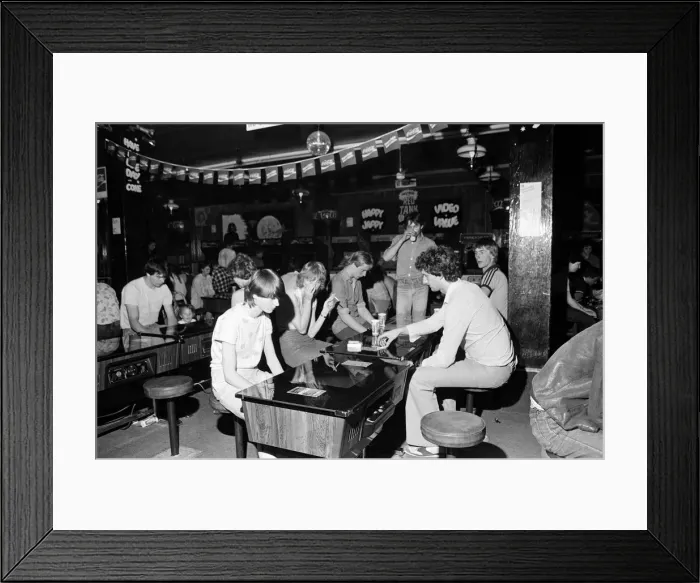 Framed Print : Young holidaymakers play the video machines at the James Corrigan seafront amusement Framed Print : Young holidaymakers play the video machines at the James Corrigan seafront amusement