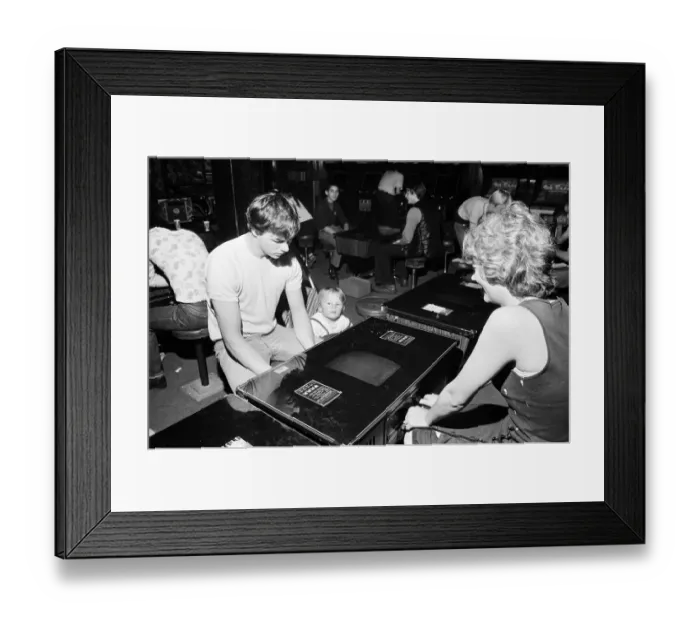 Framed Print : Young holidaymakers play the video machines at the James Corrigan seafront amusement Framed Print : Young holidaymakers play the video machines at the James Corrigan seafront amusement