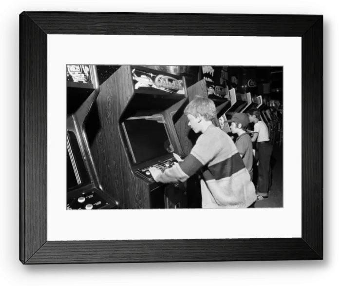 Framed Print : Young holidaymakers play the video machines at the James Corrigan seafront amusement Framed Print : Young holidaymakers play the video machines at the James Corrigan seafront amusement