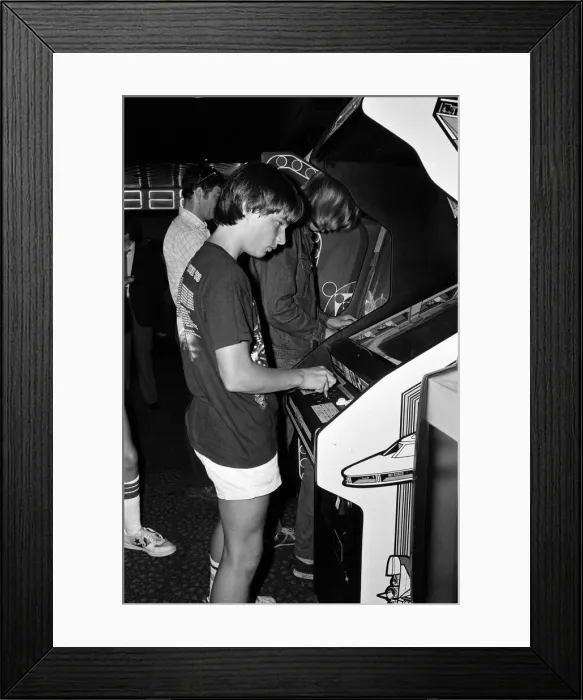 Framed Print : Young people playing video games in an amusement arcade in London. 13th July 1983 Framed Print : Young people playing video games in an amusement arcade in London. 13th July 1983