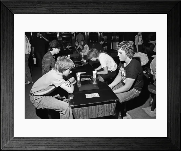 Framed Print : Young holidaymakers play the video machines at the James Corrigan seafront amusement Framed Print : Young holidaymakers play the video machines at the James Corrigan seafront amusement