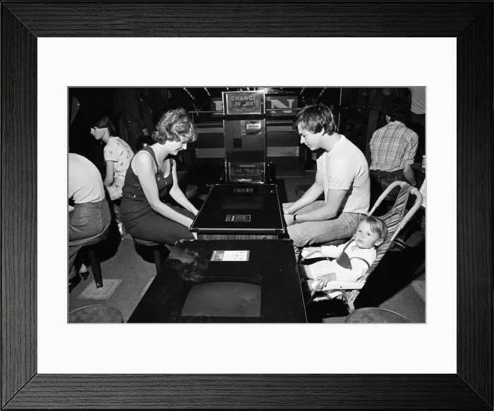 Framed Print : Young holidaymakers play the video machines at the James Corrigan seafront amusement Framed Print : Young holidaymakers play the video machines at the James Corrigan seafront amusement