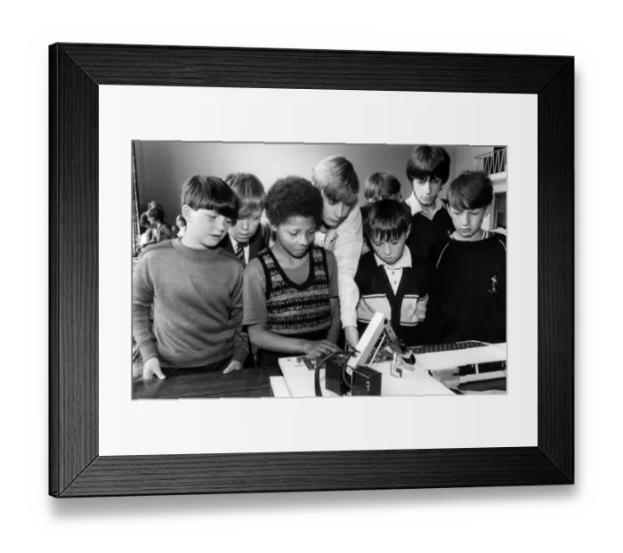 Framed Print : Jason Kamara (third left) operates a computer controlled robot watched by (left to right