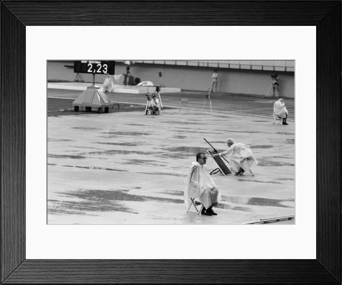 Framed Print : The 1976 Summer Olympics in Montreal, Canada. Pictured, track officials under plastic Framed Print : The 1976 Summer Olympics in Montreal, Canada. Pictured, track officials under plastic