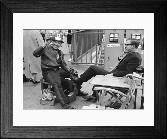 Framed Print : A Shoe Shine goes to work on a clients shoes close to the underground station
