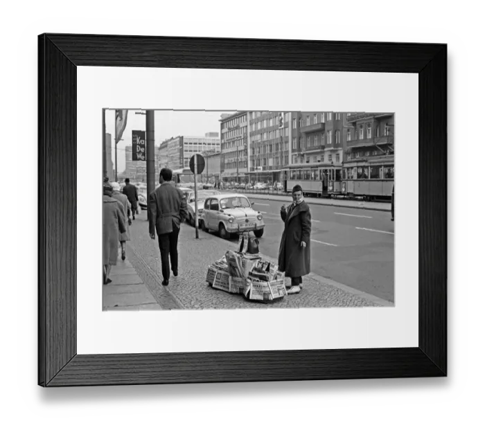 Framed Print : Newspaper vendor on the Kufurstendamm, Berlin, keeps herself warm with a cup of coffee
