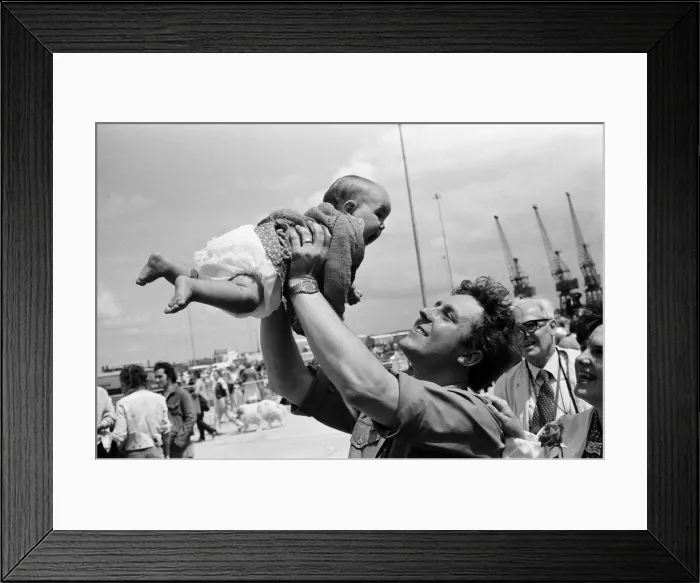 Framed Print : QE2 returns home to Southampton. Union Jacks are festooned on cars, draped on shoulders