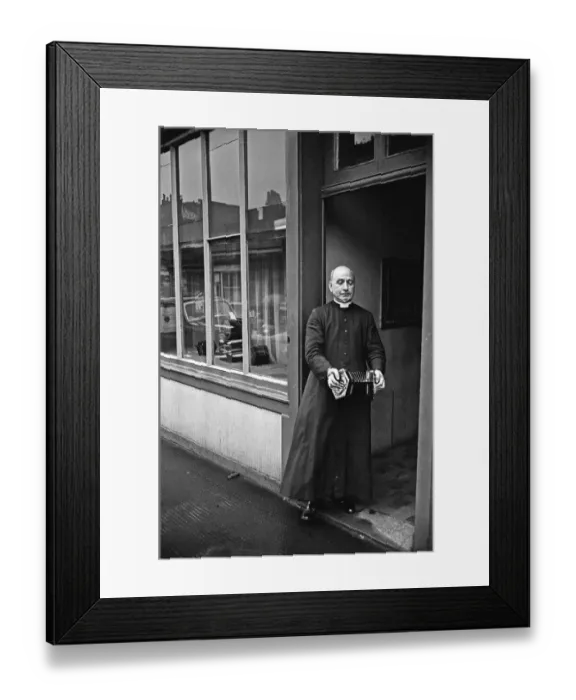 Framed Print : A priest plays a concertina outside Crabbs Concertina Shop in Liverpool Street