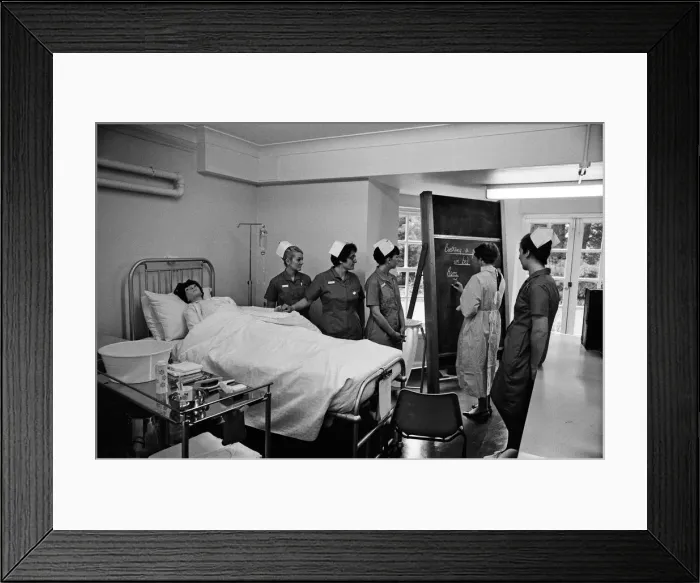 Framed Print : Nurses receiving instruction from Miss V Thomas (in surgical gown) on patient care Framed Print : Nurses receiving instruction from Miss V Thomas (in surgical gown) on patient care