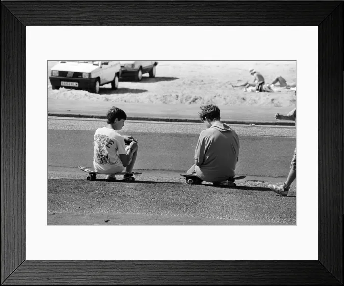 Framed Print : People enjoying a day at Crosby beach. Two boys sitting on skateboards Framed Print : People enjoying a day at Crosby beach. Two boys sitting on skateboards