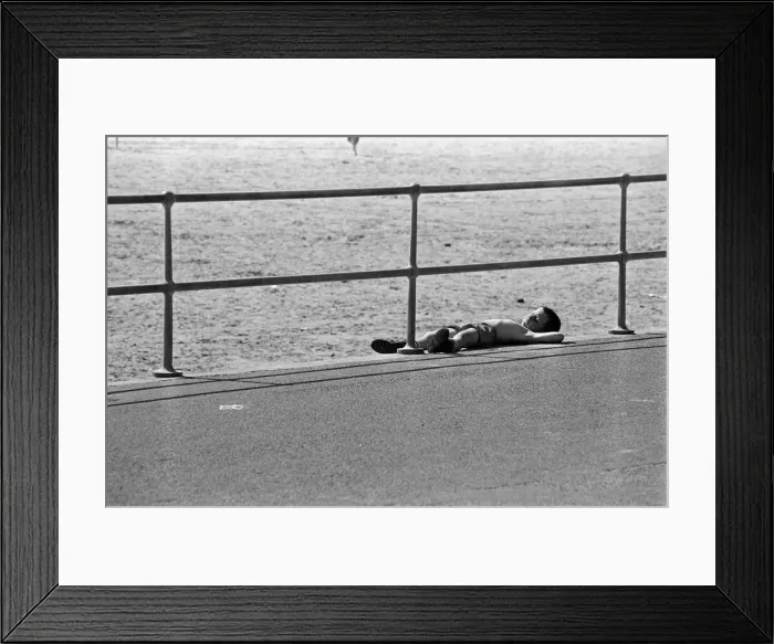 Framed Print : People enjoying a day at Crosby beach. A young boy sunbathing. Crosby, Merseyside