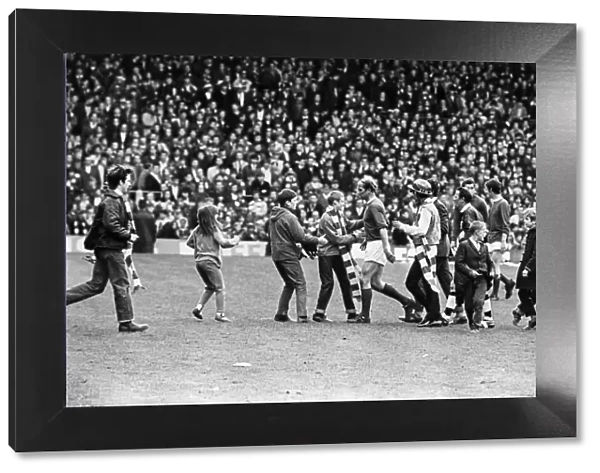 Bobby Charlton leaving the pitch at Old Trafford with young fans rushing to shake his