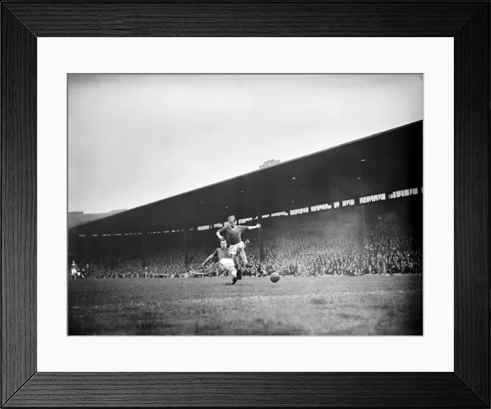 Framed Print : Bobby Charlton leaps to elude a defender during the match between Manchester United Framed Print : Bobby Charlton leaps to elude a defender during the match between Manchester United