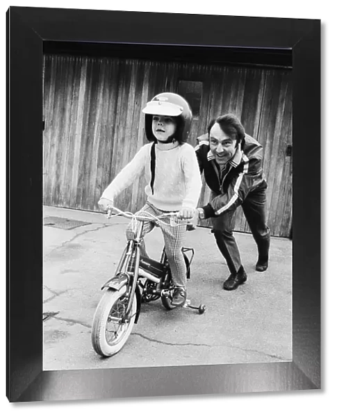 Jimmy Greaves pushing his 4-year old son Andrew, wearing his fathers crash helmet