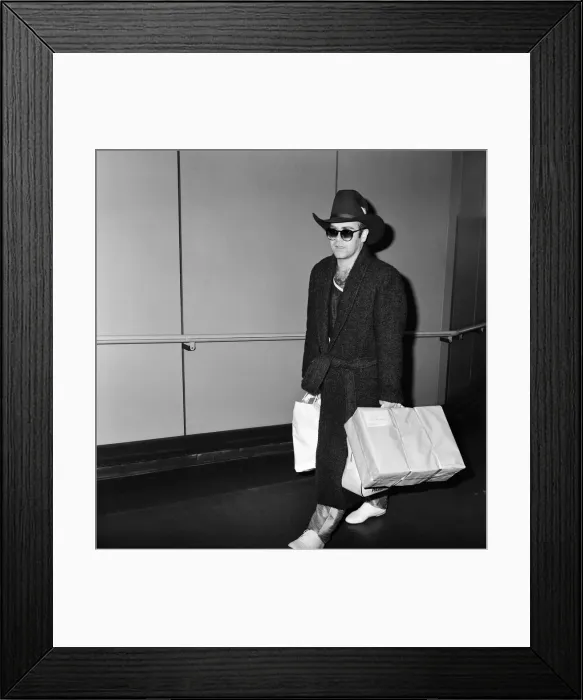 Framed Print : The arrival of Elton John at Heathrow Airport carrying Christmas presents from a buying Framed Print : The arrival of Elton John at Heathrow Airport carrying Christmas presents from a buying