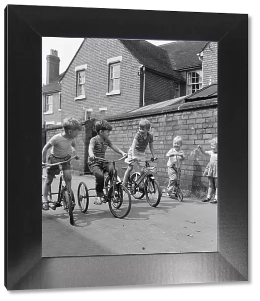 Under starters orders. Boys on their tricycles prepare to race in the back lanes of