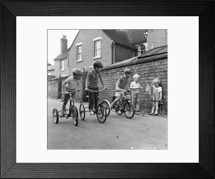 Framed Print : Under starters orders. Boys on their tricycles prepare to race in the back lanes of Framed Print : Under starters orders. Boys on their tricycles prepare to race in the back lanes of