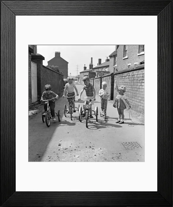 Framed Print : Under starters orders. Boys on their tricycles prepare to race in the back lanes of Framed Print : Under starters orders. Boys on their tricycles prepare to race in the back lanes of