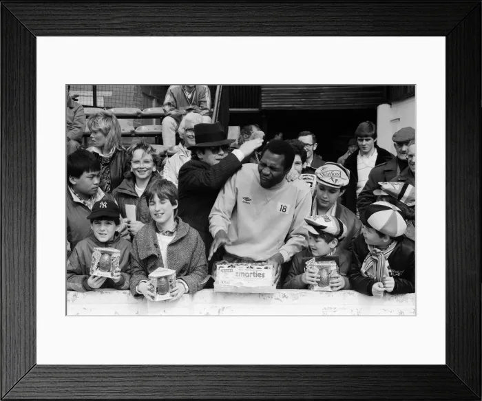 Framed Print : Pop star and Watford FC Chairman, Elton John, handing out Easter eggs to fans Framed Print : Pop star and Watford FC Chairman, Elton John, handing out Easter eggs to fans