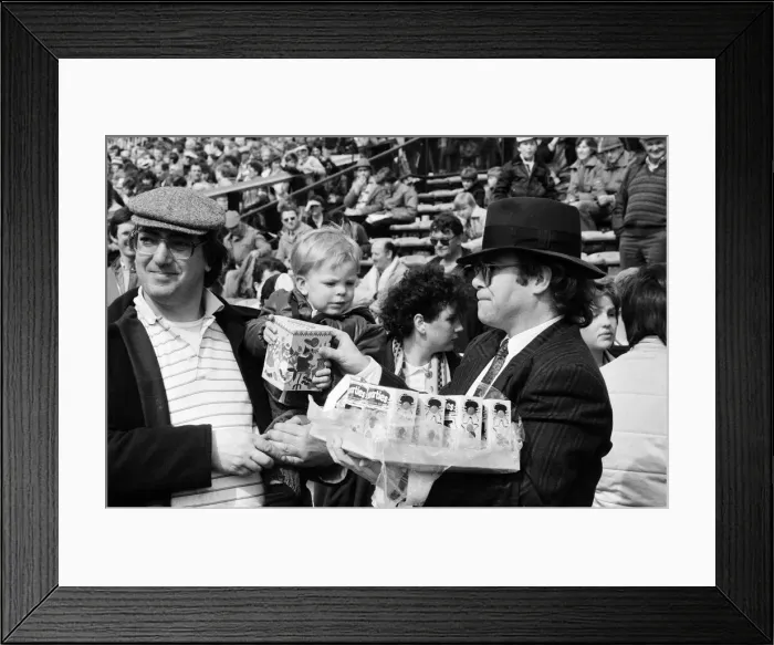 Framed Print : Pop star and Watford FC Chairman, Elton John, handing out Easter eggs to fans Framed Print : Pop star and Watford FC Chairman, Elton John, handing out Easter eggs to fans