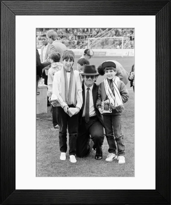 Framed Print : Pop star and Watford FC Chairman, Elton John, handing out Easter eggs to fans