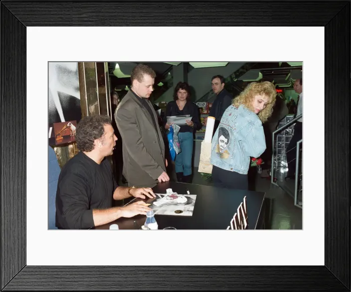 Framed Print : Tom Jones signs the knickers and jacket of his fan Kathy Hall at HMV Oxford Street