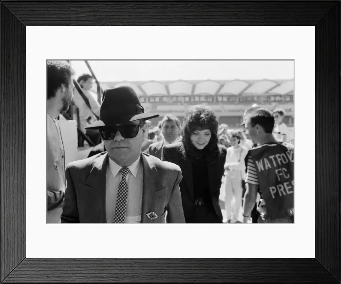 Framed Print : Elton John and his wife Renate arriving to watch his team, Watford, play a football match Framed Print : Elton John and his wife Renate arriving to watch his team, Watford, play a football match