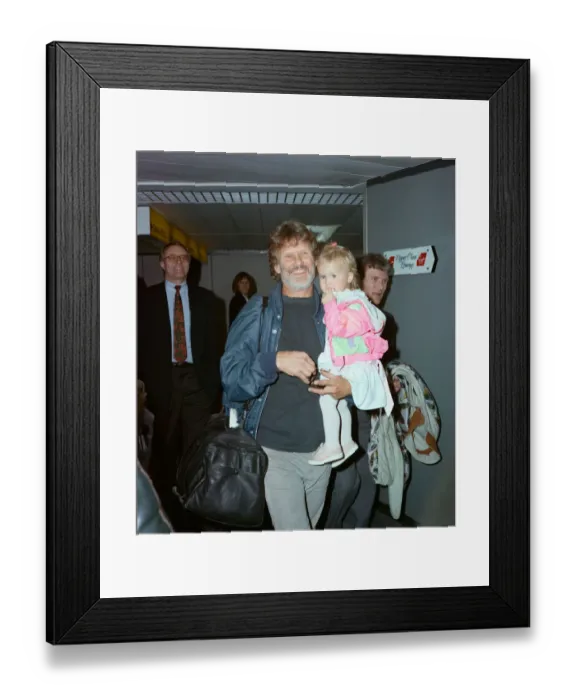 Framed Print : Members of The Highwaymen at Heathrow Airport. Kris Kristofferson and children