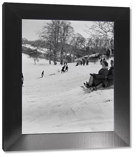 Why should the children only have fun, as two women take part in sledging in Stoke Park